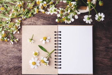 Boş defter ile beyaz çiçek ve bas ket çiçek vintage ahşap Tablo görünümü yukarıdan kopya alanı