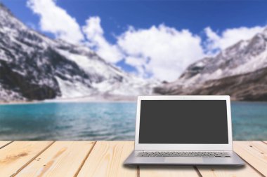 Göl ve deniz ile ahşap masa boş ekran ile dizüstü bilgisayar