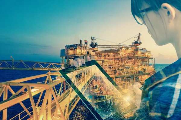Double exposure of businesswoman in hipster shirt and wearing glasses working with tablet and oil and gas refinery industry plant in the night as Energy and Technology concept. — Stock Photo, Image