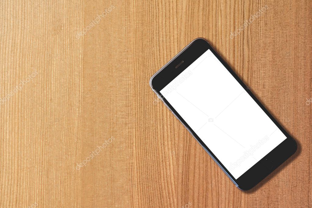 Blank smart phone on wooden table background
