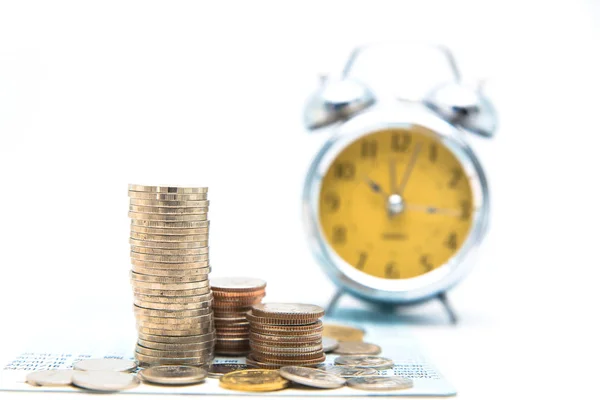 Stack of coins with vintage clock on white background for mocup — Stock Photo, Image