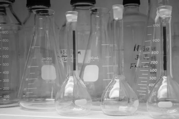 Vetreria da laboratorio o becher in pile di toni freddi e vintage su scaffale, ricerca scientifica, concetto di scienza — Foto Stock