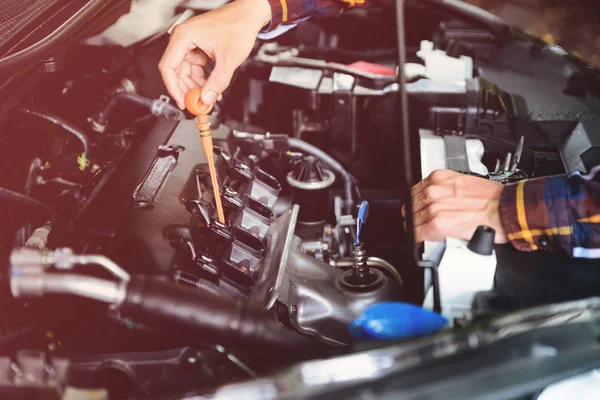 Close up hands checking lube oil level of car engine from deep-s