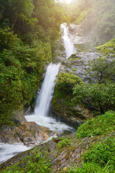 Waterfall in rain forest with flare of sun light at Mae Pan wate — Stock Photo, Image