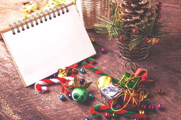 Noel ve yeni yıl ahşap arka plan afiş ile boş defter, hediye kutusu, papatya çiçek, topu şeker ve vintage çam süs kamışı