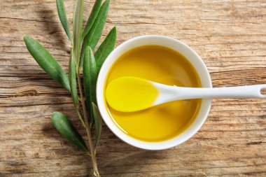 Zeytinyağı ve zeytin dal ahşap bir masa üzerinde