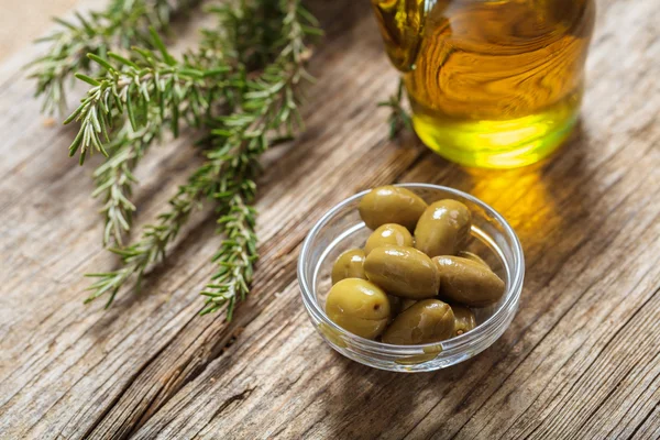 Olive e olio d'oliva su un tavolo — Foto Stock