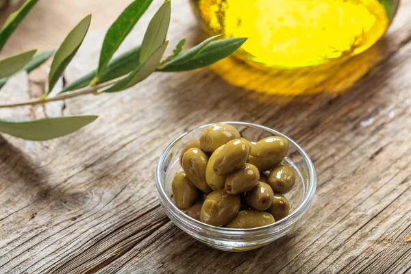 Aceitunas y aceite de oliva sobre una mesa — Foto de Stock