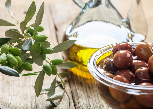 Aceitunas y aceite de oliva sobre una mesa — Foto de Stock