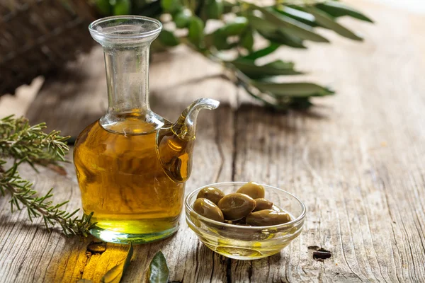 Оливкова олія та оливкова гілочка на столі — стокове фото