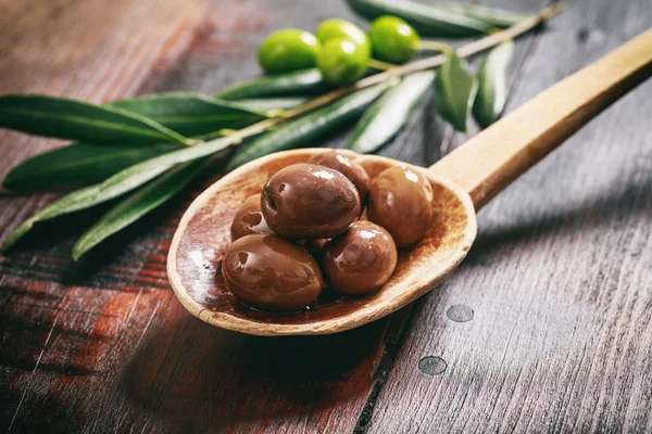 Olives in a wooden ladle — Stock Photo, Image