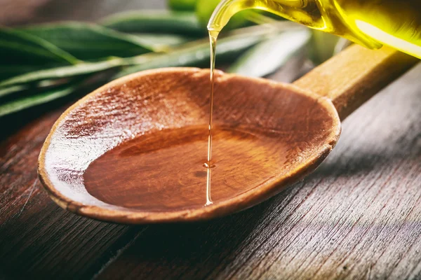 Cucchiaio di legno con olive e olio d'oliva — Foto Stock