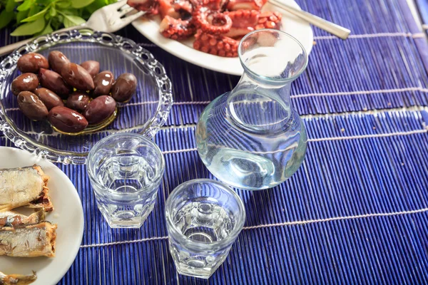 Two glasses of ouzo and appetizers — Stock Photo, Image