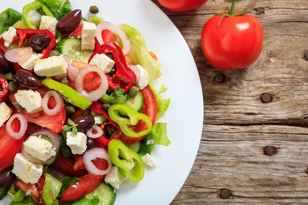 Greek salad on wooden background — Stock Photo, Image