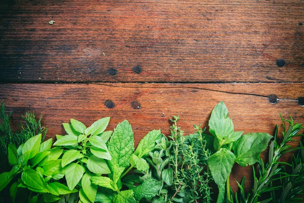 Herbs on a wooden surface — Stock Photo, Image