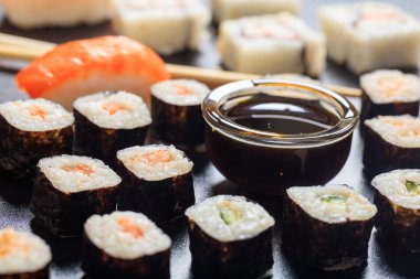 Siyah bir yüzey üzerinde suşi rulo