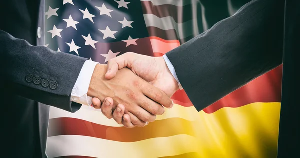 Рукостискання на США - Німеччина прапорів фону — стокове фото