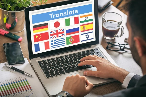 Man working on a laptop - translate on the screen — Stock Photo, Image