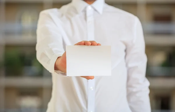 Empresário segurando um cartão em branco — Fotografia de Stock