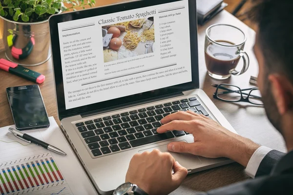 Homem trabalhando em um laptop - receita na tela — Fotografia de Stock