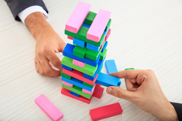 Бизнесмены играют в деревянные блоки
