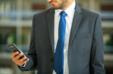 bir akıllı telefon tutarak işadamı 