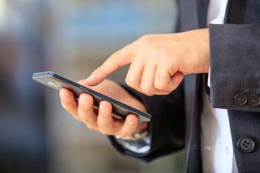 bir akıllı telefon tutarak işadamı 