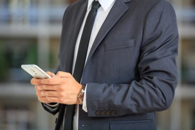 bir akıllı telefon tutarak işadamı 