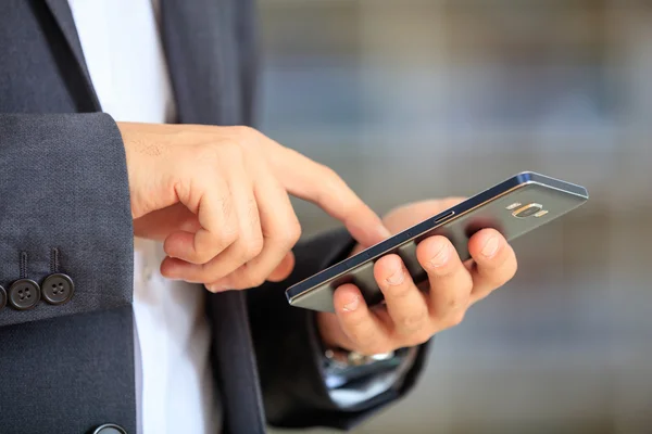 Hombre de negocios sosteniendo un smartphone —  Fotos de Stock