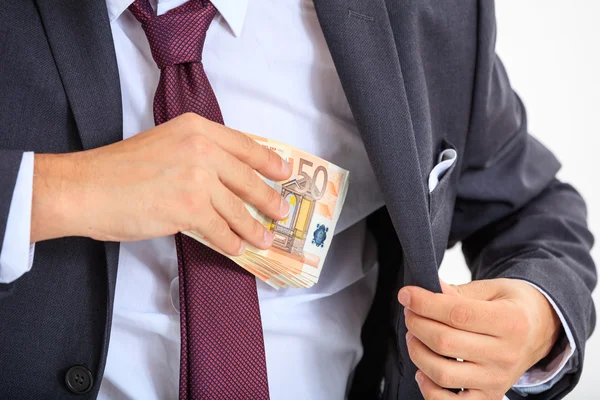 Businessman putting money in his suit — Stock Photo, Image