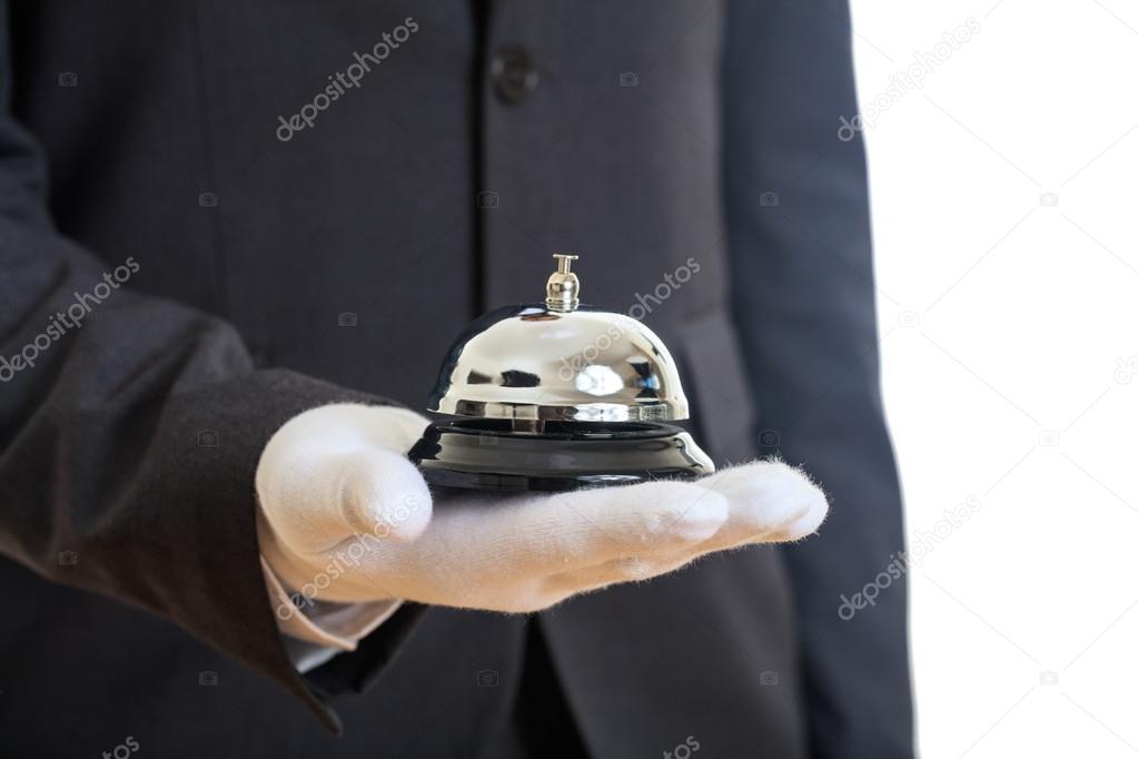 Butler service bell in a gloved hand