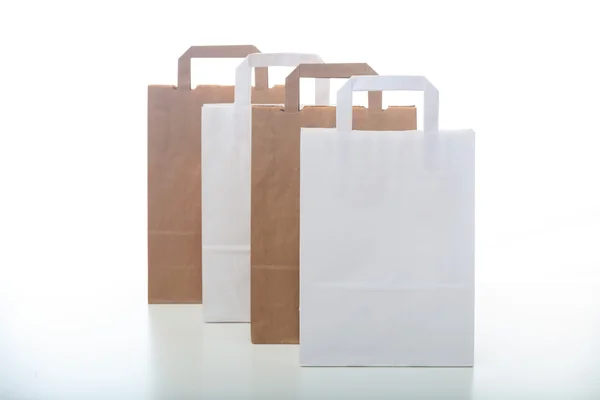 Sacos de compras de papel marrom e branco no fundo branco — Fotografia de Stock