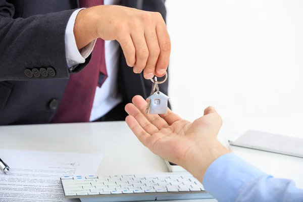 Man in suit offering a key — Stock Photo, Image