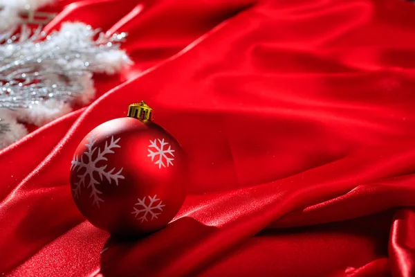 Christmas ball on red satin — Stock Photo, Image