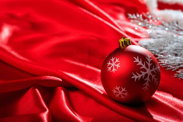 Χριστουγεννιάτικη μπάλα στο κόκκινο σατέν — Φωτογραφία Αρχείου