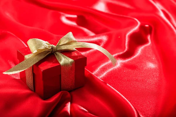 礼品盒红色缎背景上 — 图库照片