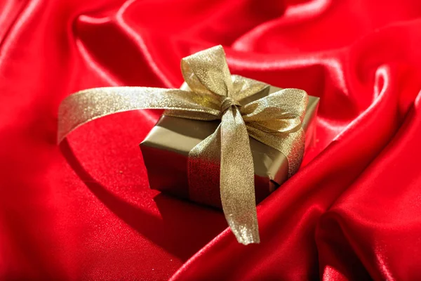 Gift box on a red satin background — Stock Photo, Image