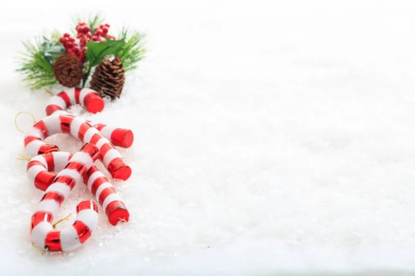 Cones de pinheiro e bengalas doces na neve — Fotografia de Stock