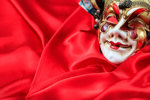 Máscara de carnaval no fundo de cetim vermelho — Fotografia de Stock