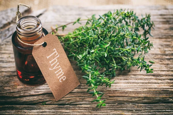 Aceite de tomillo sobre fondo de madera — Foto de Stock