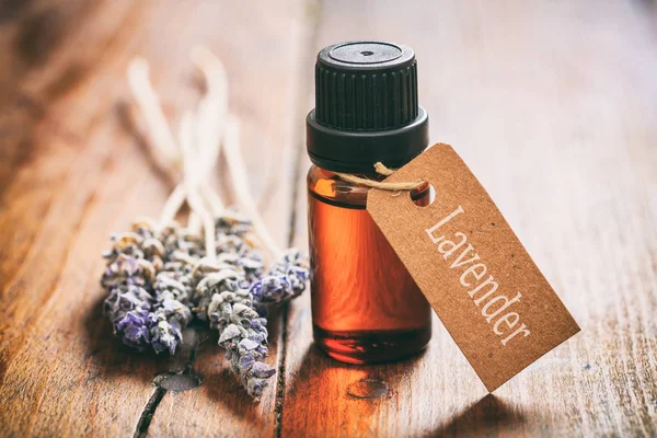 Manojo de lavanda y aceite sobre fondo de madera — Foto de Stock