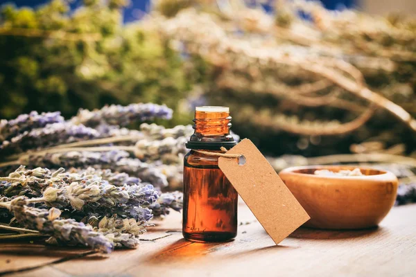 Lavendelstrauß und Öl auf Holzgrund — Stockfoto
