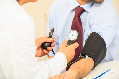 Doktor kan basıncını ölçüyor.