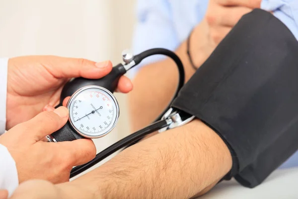 Médico midiendo presión arterial — Foto de Stock