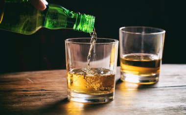 Ahşap bir masa viskiyle bardak