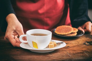 Bir fincan çay tutan garson