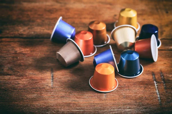 Cápsulas espresso coloridas em fundo de madeira — Fotografia de Stock