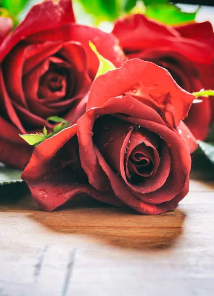 Ahşap arka planda kırmızı güller — Stok fotoğraf