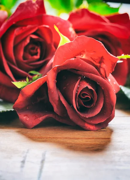 Rosas vermelhas no fundo de madeira — Fotografia de Stock