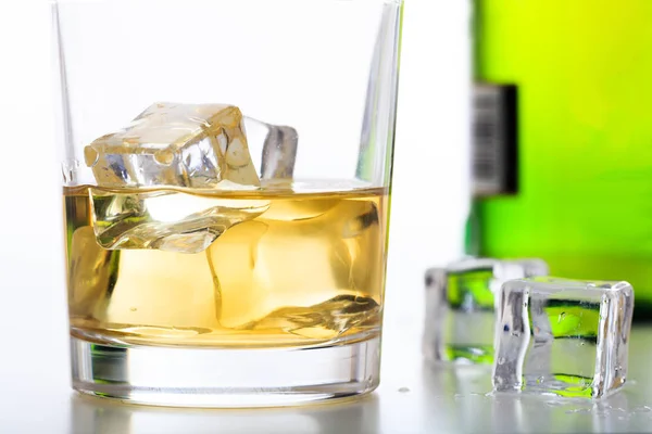 Vaso de whisky y hielo sobre fondo blanco — Foto de Stock
